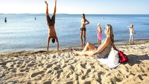 A beach scene with people relaxing and engaging in activities. - Ferienhaus im Ferienpark Mueritz (Rechlin)