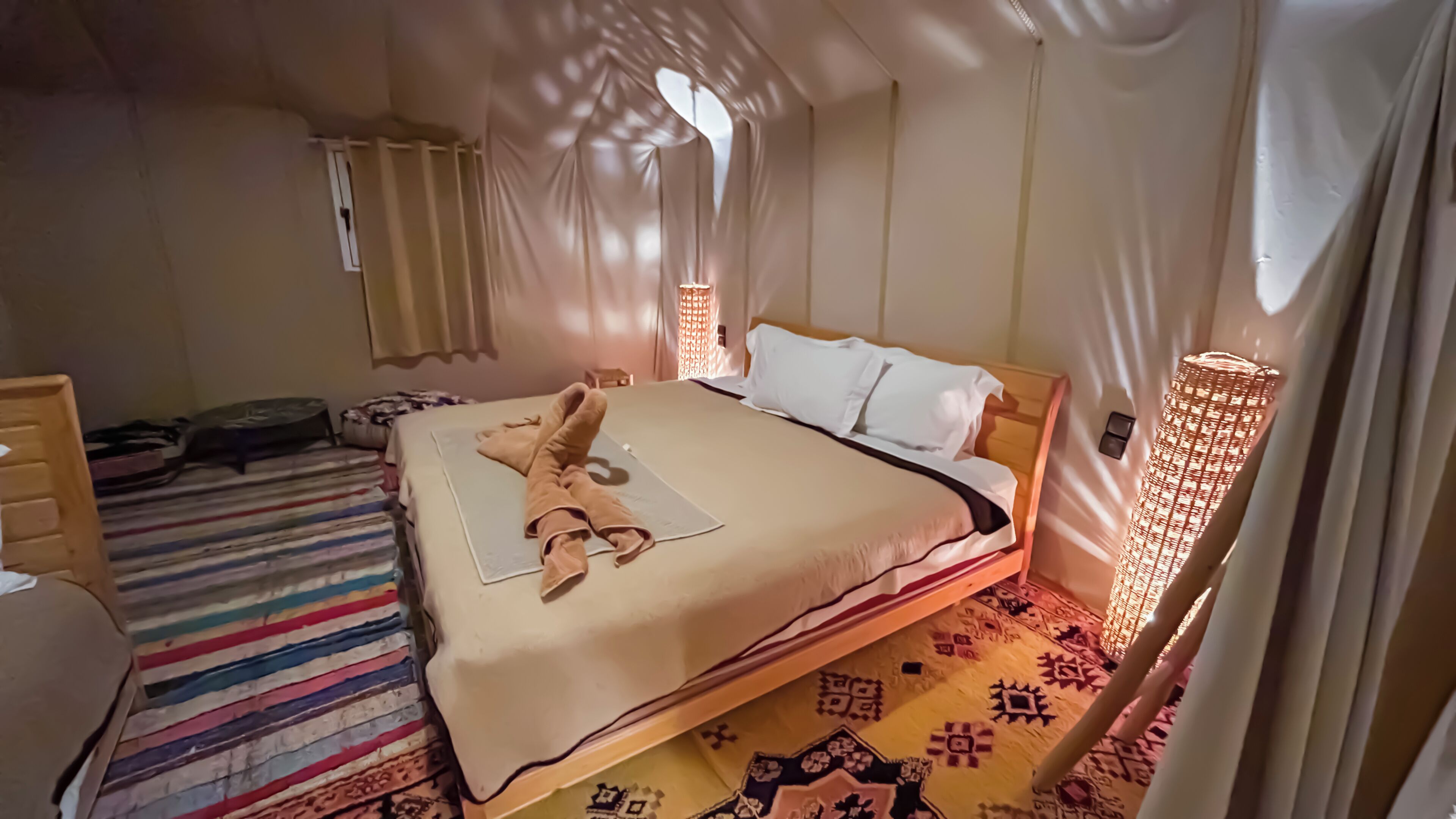 A room with a bed, a bedside table, a chair, and a patterned rug.
