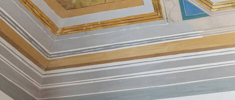 A room with a decorative ceiling and a white air conditioning unit.