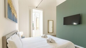 Une chambre d’hôtel avec un lit, un téléviseur à écran plat, un tableau et une vue sur l’extérieur.
