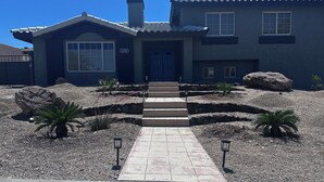 A two-story house with a blue exterior, a front door, and a number '2250' sign.