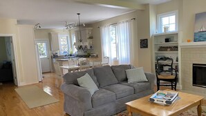 A living room with a grey sofa, wooden coffee table, and a fireplace. - Charming 4-bedroom house near the Lakeside pool & pickleball courts (Lakeside)