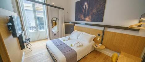 A hotel room with a bed, bedside table, and a large window.