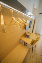 Una cucina moderna con mobili in legno, un portatile su un tavolo e un appendiabiti a parete.