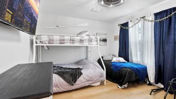 A bedroom with a bunk bed, a desk, and a chair.