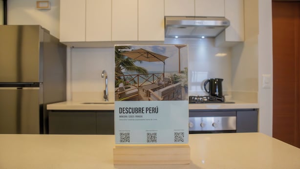 Una cocina con armarios blancos, un refrigerador de acero inoxidable y una cafetera.