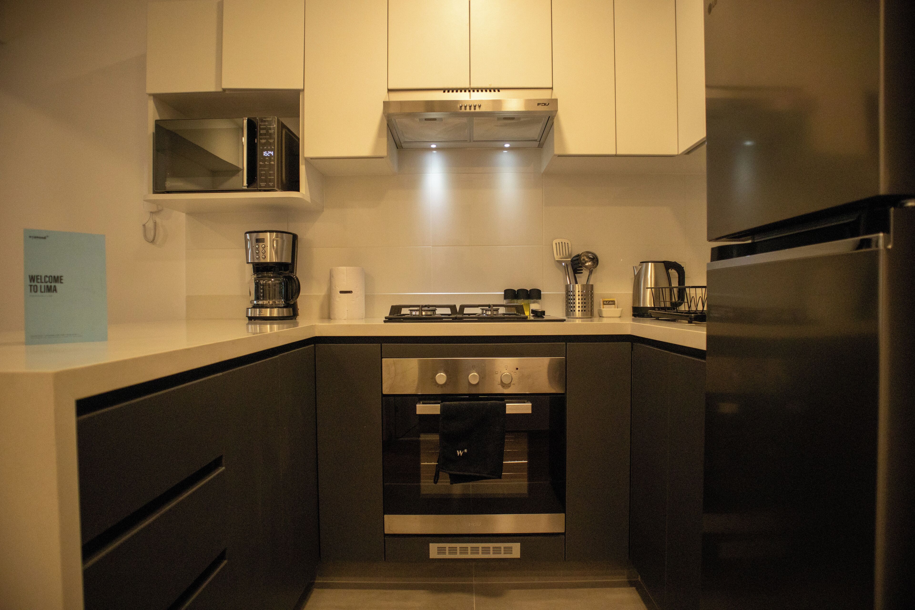 A compact kitchen with a built-in microwave, stove, oven, and refrigerator.