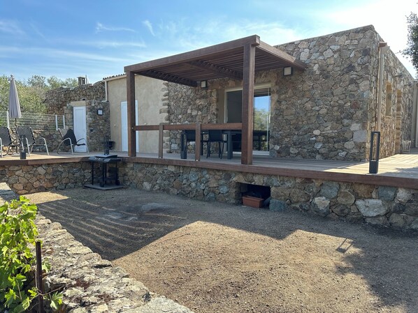 A stone building with a wooden deck and outdoor seating area.