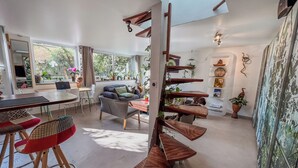Een moderne woonruimte met een eethoek, een bank en een unieke houten wandplank.