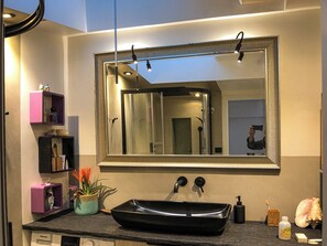 Een douche, een bidet, handdoeken, toiletpapier