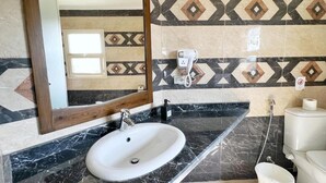 A bathroom with a white sink, black marble countertop, and patterned tile walls. - Spacious 4-bedroom apartment with WiFi, AC in fantastic Giza Governorate (Giza Governorate)