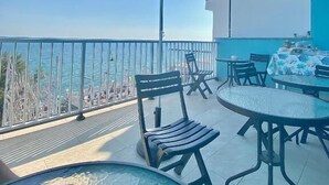 A balcony with a blue umbrella, chairs, a table, and a view of the sea. - Acquamarina B&B Deluxe (Cariati)