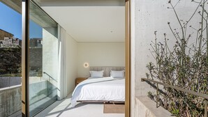 A modern bedroom with a large bed, a nightstand, and a wall-mounted light. - GuestReady - DPV GuestHouse - Apart 6 (Porto)