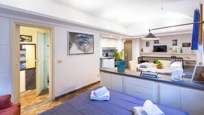 Ett modernt hotellrum med en säng, ett nattduksbord och utsikt över köket.