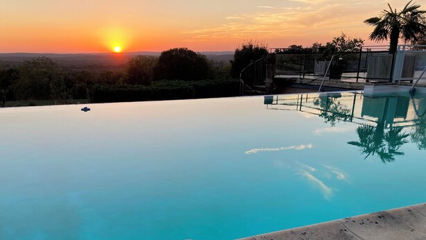 Vista despejada de una piscina al atardecer con un paisaje lejano.