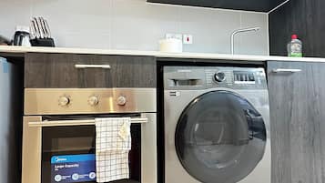 Appartamento Deluxe, balcone, vista città | Cucina privata | Frigorifero con congelatore, forno, piano cottura