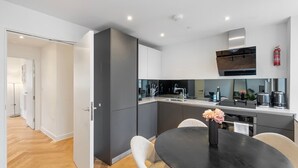Une cuisine moderne dotée d’un îlot central, d’appareils électroménagers intégrés et d’un coin repas avec une table ronde et des chaises.