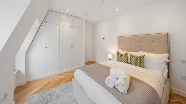Un dormitorio con una cama grande, un armario y una escalera.