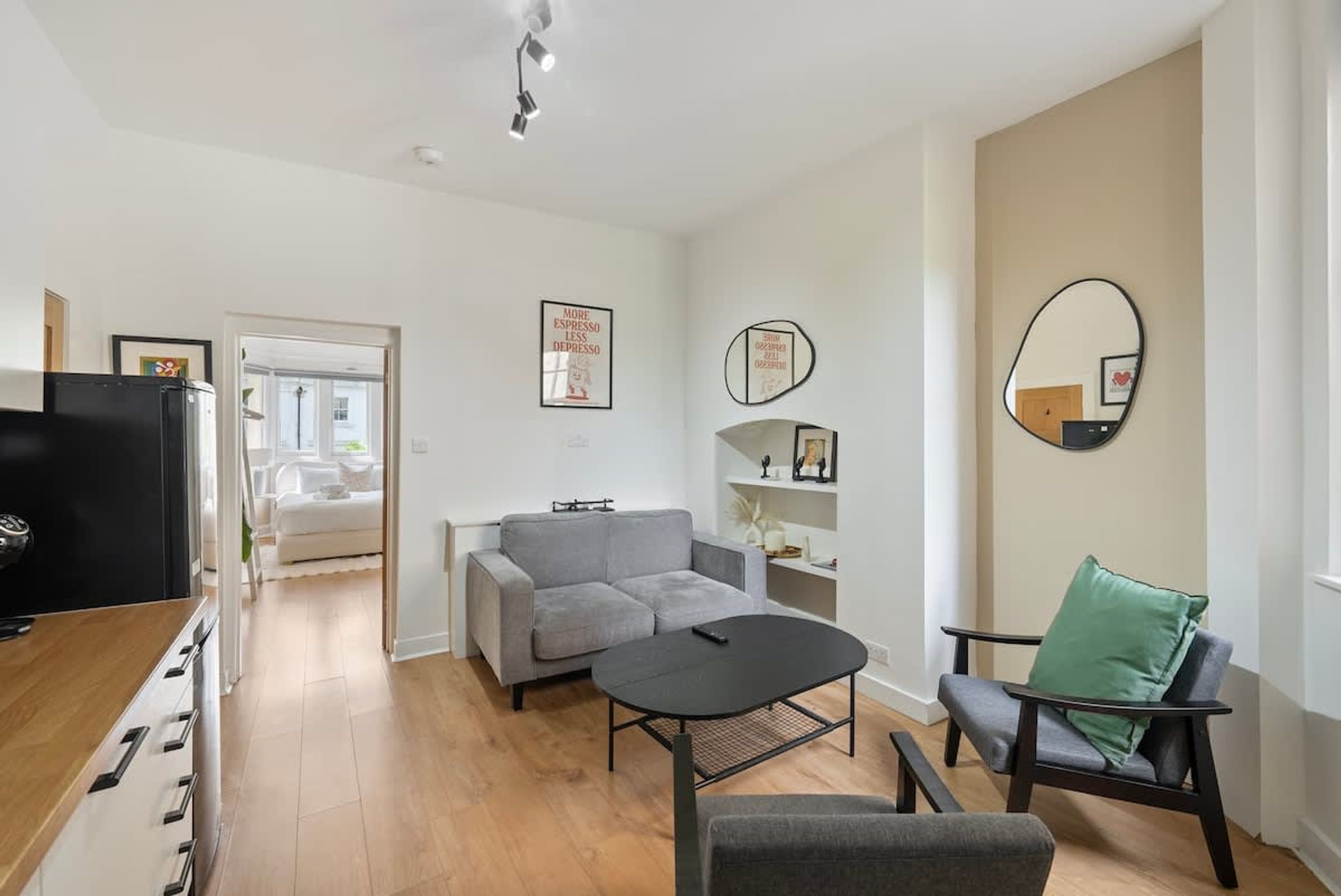 A modern living room with a sofa, a coffee table, a TV, and a chair.