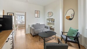 Una sala moderna con un sofá, una mesa de centro, un televisor y una silla.