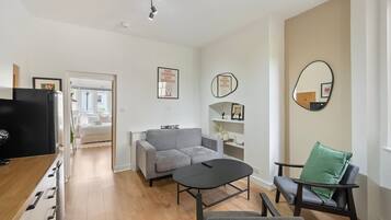 A modern living room with a sofa, a coffee table, a TV, and a chair.