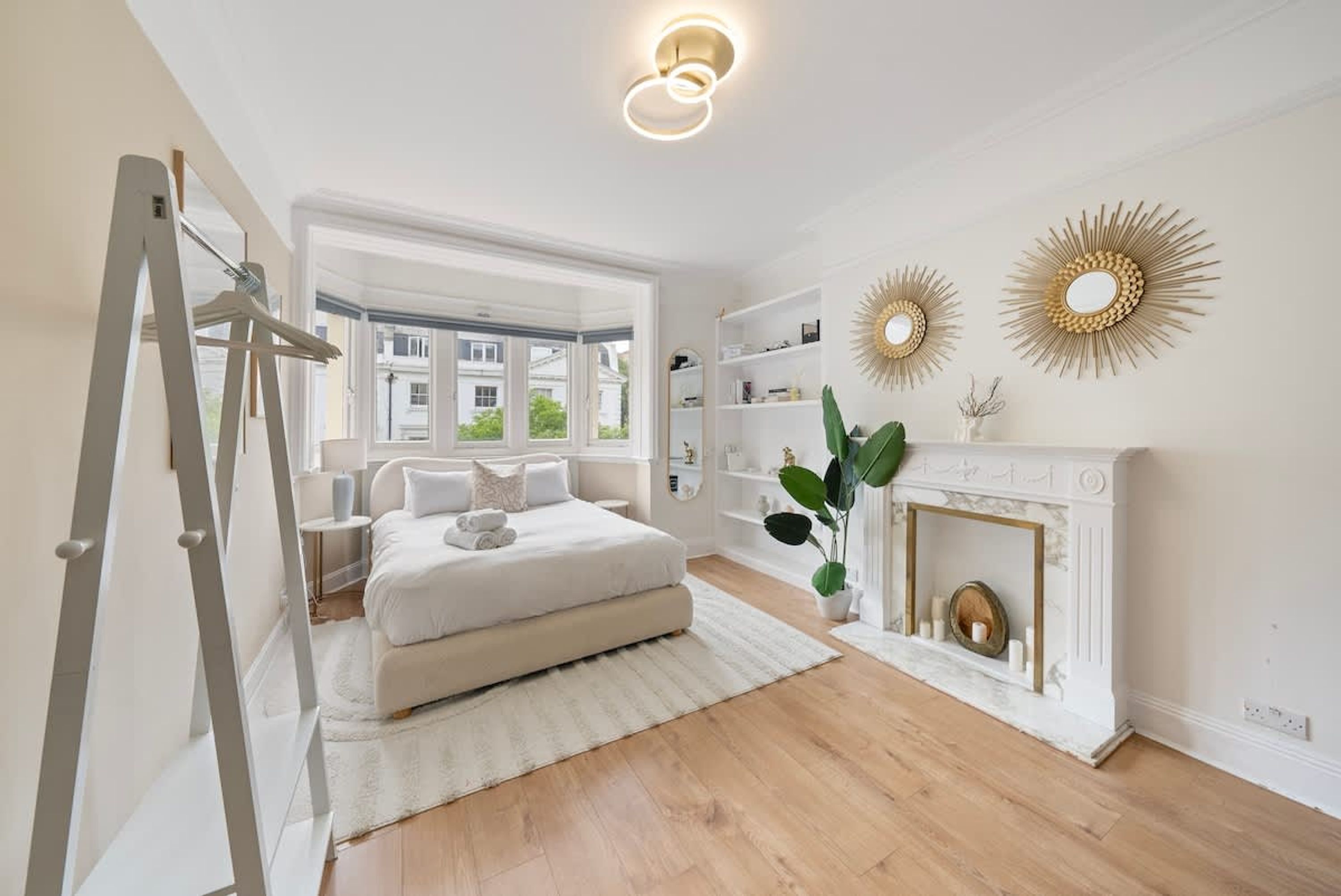 A bedroom with a bed, a fireplace, and a view of the outside.