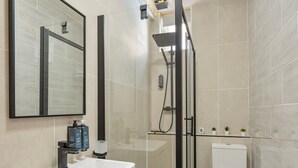 Un baño moderno con ducha, inodoro y lavabo.