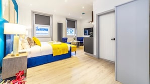 Une chambre à coucher moderne, avec un lit, une table de chevet, une lampe et une vue sur la ville par la fenêtre.