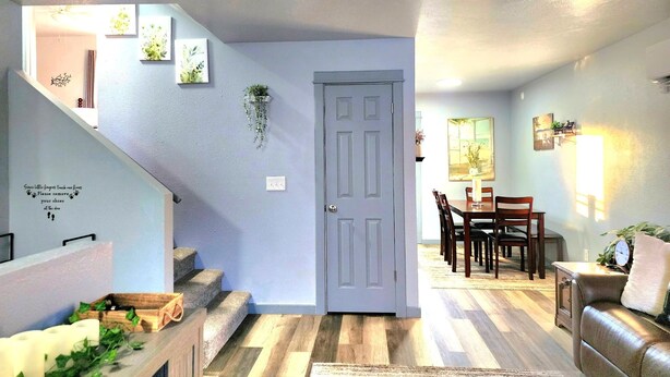 Ein modernes Wohnzimmer mit Treppe, Essbereich und einer Tür zu einem anderen Raum.