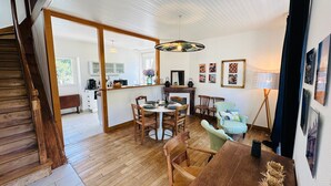 A spacious dining area with a wooden table and chairs, a large mirror, and a hanging light fixture. - Ti an dour, entre terre et mer (Crac'h)