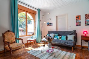 A cozy living room with a sofa, a wooden chair, a coffee table, and a vase with flowers. - Ti an dour, entre terre et mer (Crac'h)