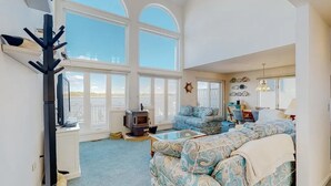 A spacious living room with a large window, a fireplace, a sofa, and a coffee table. - Charming 4-bedroom house with WiFi and AC in tranquil Ocean Pines (Ocean Pines)