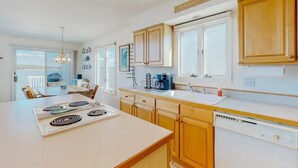 A modern kitchen with a central island, wooden cabinets, and a dishwasher. - Charming 4-bedroom house with WiFi and AC in tranquil Ocean Pines (Ocean Pines)
