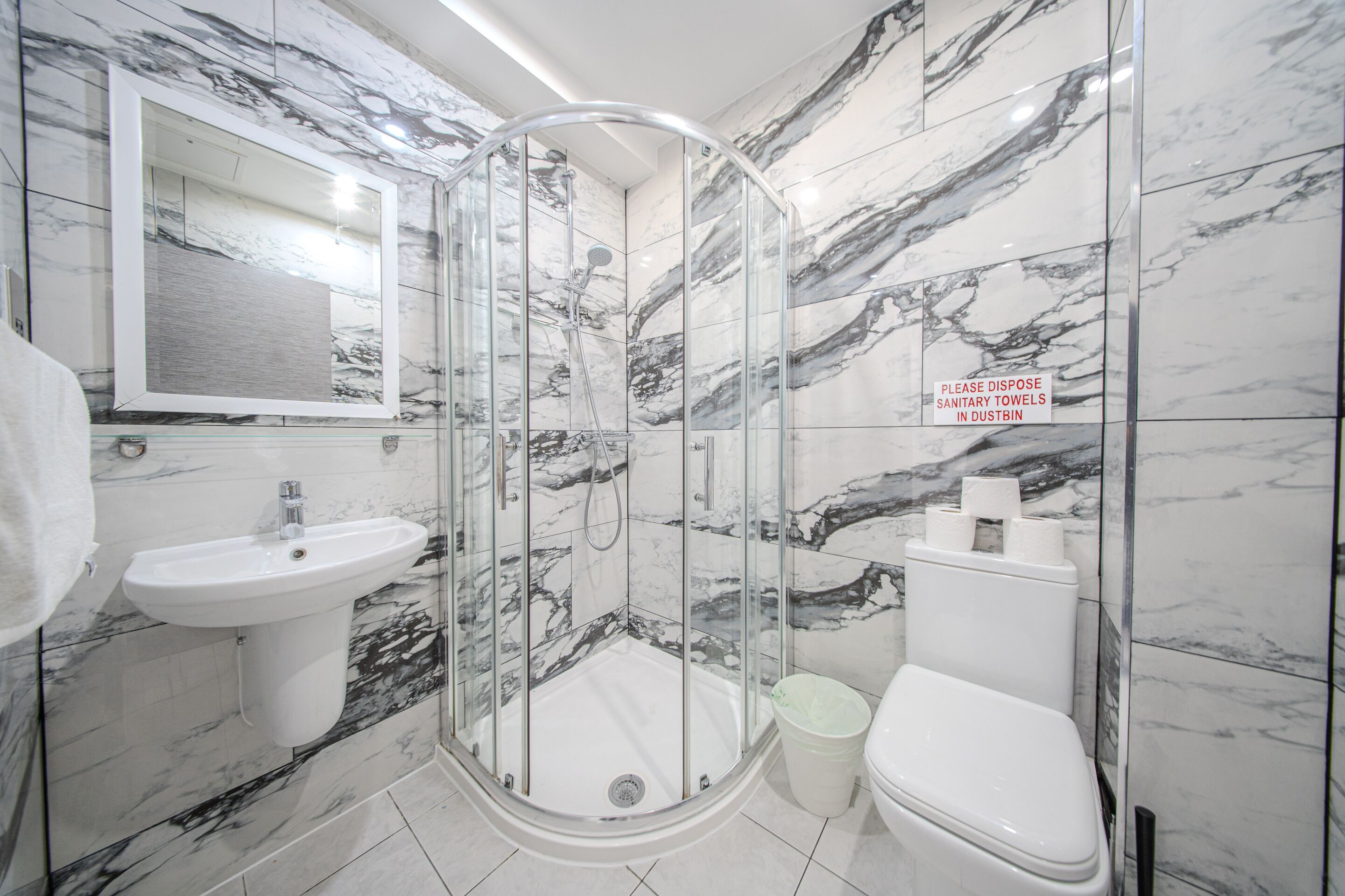 Ein modernes Badezimmer mit einer Duschkabine, einem Waschbecken und einer Toilette.