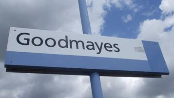 Een bord met de tekst 'Goodmays' voor een bewolkte lucht.