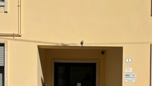 Entrada d'edifici amb una porta de vidre, una escala ascendent i un senyal que indica una zona per a gravació de vídeo.