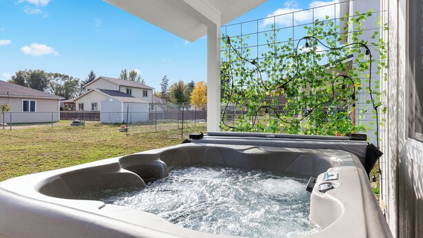 A hot tub with water, a window, and a view of houses and a fence. - Mtn View Getaway - w/ Hot Tub, Close to Schweitzer (Kootenai)