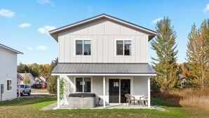 A two-story house with a front porch, a covered patio, and a trash can. - Mtn View Getaway - w/ Hot Tub, Close to Schweitzer (Kootenai)