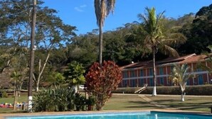 A pool area with palm trees and a building in the background.