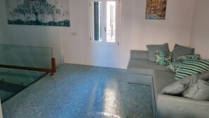 A living room with a glass table, a sofa with patterned cushions, a tiled floor, and artwork on the walls. - Cozy property on the Amalfi Coast close to the most beautiful beaches (Raito)