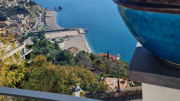 A coastal cityscape with a view of the sea, buildings, and a large blue vase on a balcony. - Cozy property on the Amalfi Coast close to the most beautiful beaches (Raito)