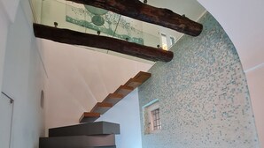 A modern staircase with wooden beams and a tiled wall. - Cozy property on the Amalfi Coast close to the most beautiful beaches (Raito)