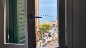 A window with a view of the sea, a balcony with railings, and a door with a handle. - Cozy property on the Amalfi Coast close to the most beautiful beaches (Raito)
