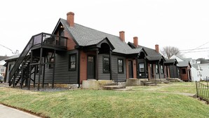 Une maison à deux étages avec un balcon, un porche à l’avant et une cheminée.