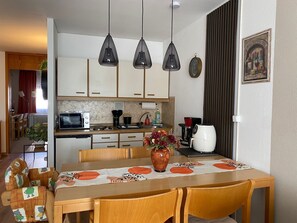 Enjoy a functional kitchen and dining area with modern appliances and a cozy table setting.