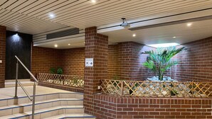 A staircase with beige tiles and metal railings, surrounded by brick walls and a small plant. - 2 room family apartment "Vier Jahreszeiten" (Sankt Englmar)