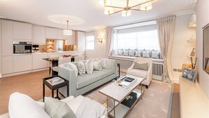 Ein modernes Wohnzimmer mit Sofa, Couchtisch und Essbereich.