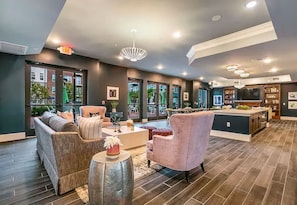 A modern living room with a sofa, armchairs, and a coffee table. There is a kitchen area with a dining table and chairs. - Stylish 1BR Family Apartment by Dtla (Los Angeles)