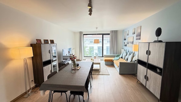 Un appartement moderne comprenant un coin repas, un canapé et un meuble.