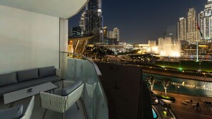 A balcony with a sofa, chairs, and a table. - One Lux Stay Grande Signature Residences (Dubai)